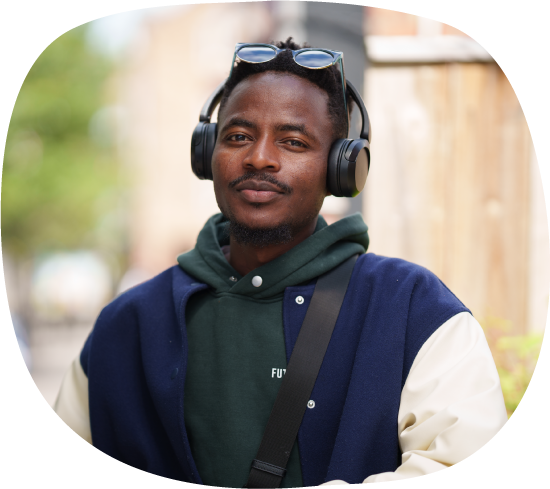 A photograph of Ishmail, who was supported by Thrive Darlington to live independently and gain employment. He is looking straight at the camera, wearing sunglasses and headphones on his head.
