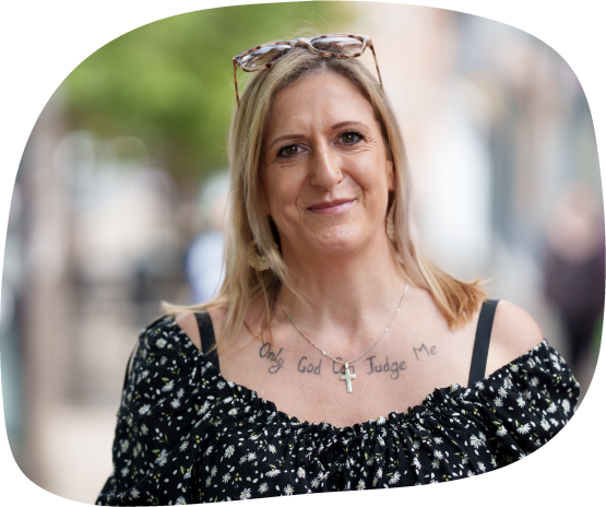 A photograph of Melissa, who is a member of Waythrough's Life Experience Council. She has blonde hair, is wearing a patterned blouse, and is smiling straight at the camera.