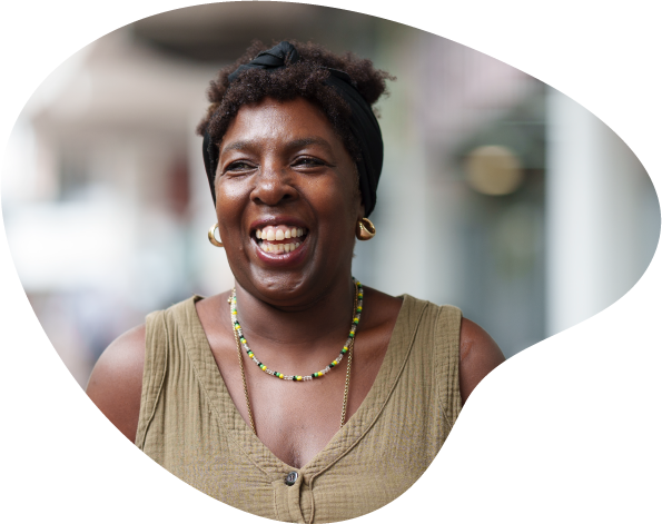 A photograph of Pauline, a Peer Mentor Volunteer at Enable. She is looking slightly to the side of the camera and smiling.