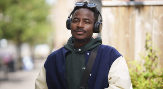 A photograph of Ishmail, who was supported by Thrive Darlington to live independently and gain employment. He is looking straight at the camera, wearing sunglasses and headphones on his head.